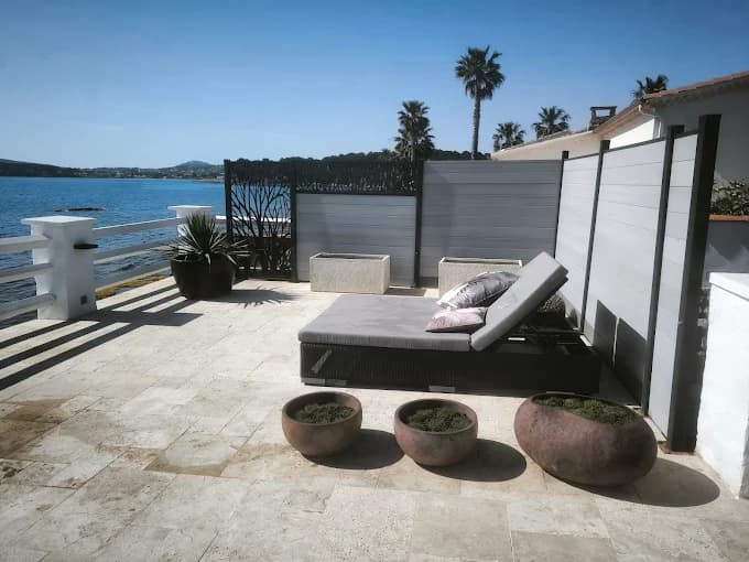 Terrasse en pierre face à la mer aménagée par Cyrus Paysage