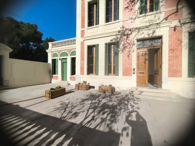 Cour d'une bâtisse en brique rénovée avec jardinières en bois