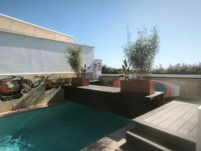 Terrasse en bois bordant une piscine avec bambous